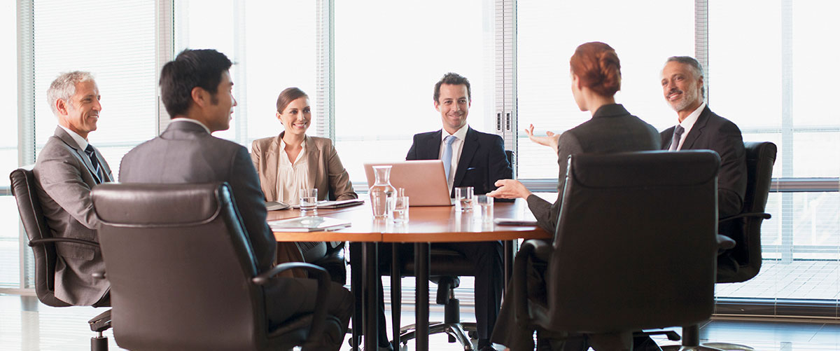 Businesspeople meeting at table in conference room, office, group