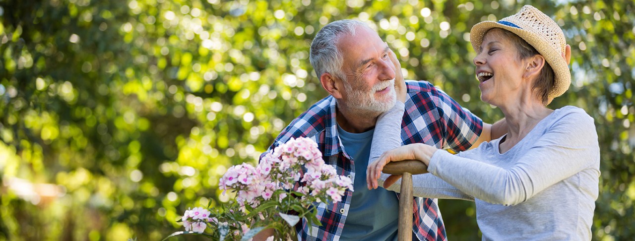 Senior couple interacting with each other in a garden, flower, tree, man, woman